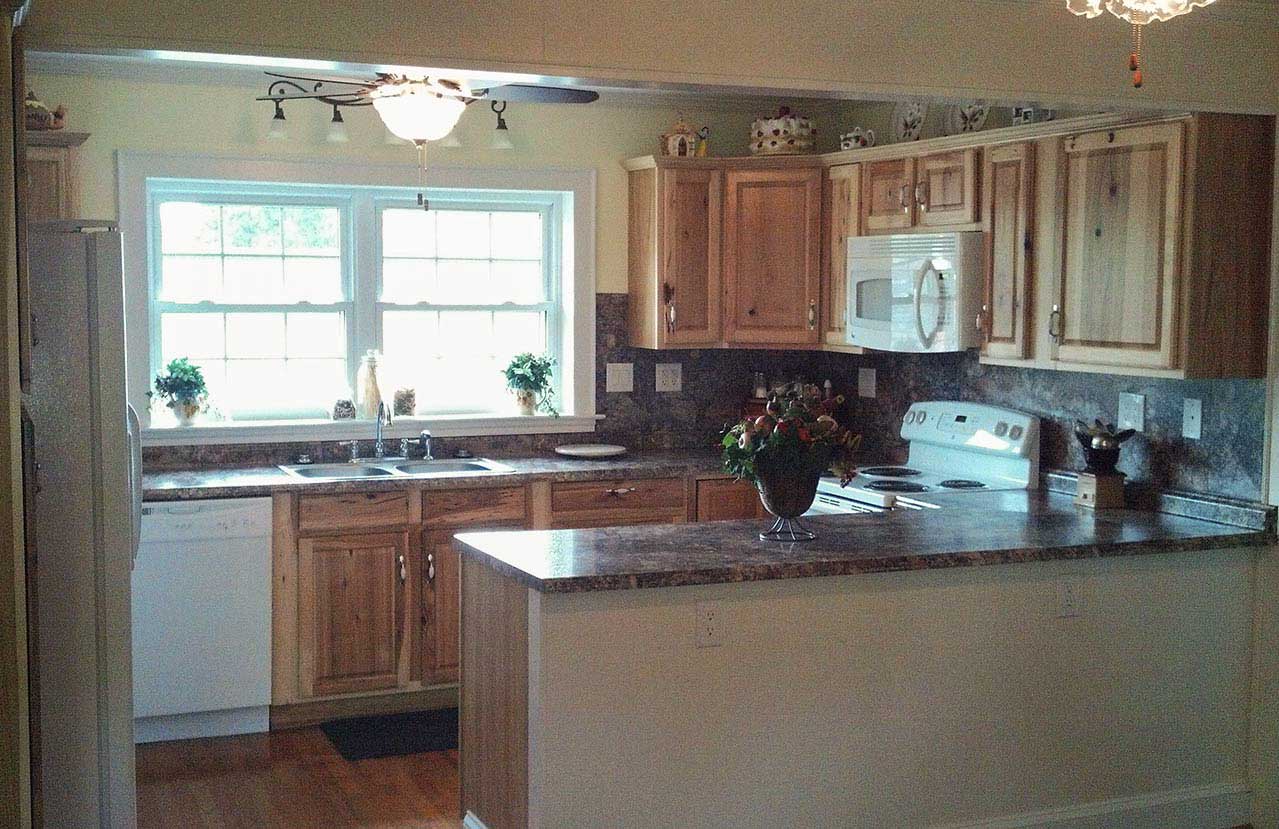Small kitchen with natural wood cabinetry after remodeling